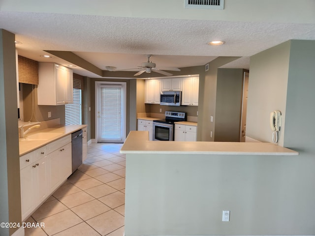 kitchen with stainless steel appliances, white cabinets, sink, and kitchen peninsula