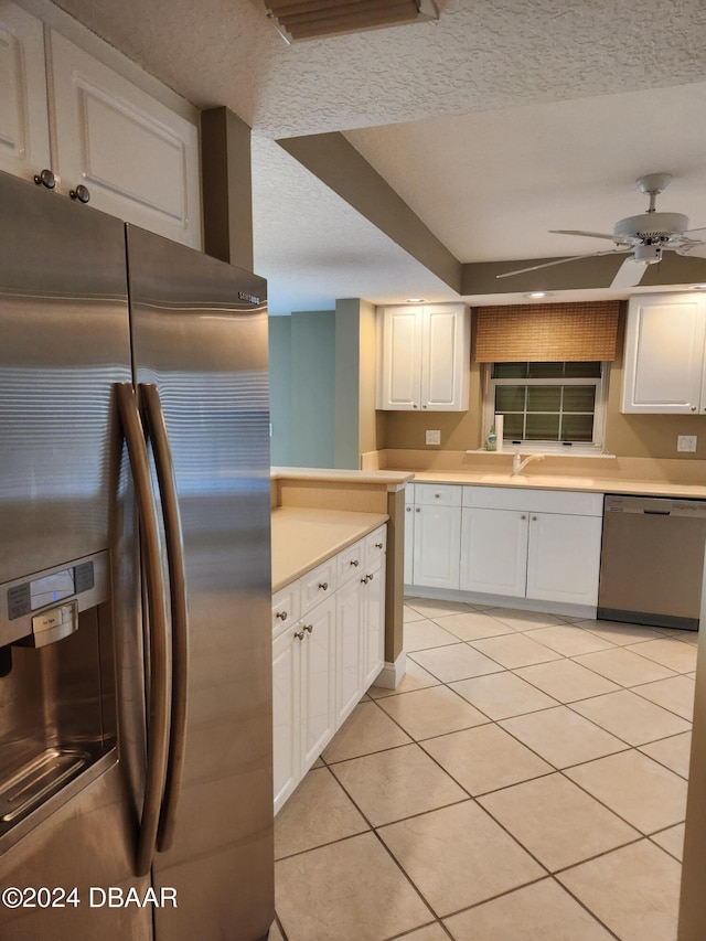 kitchen with stainless steel appliances, white cabinetry, ceiling fan, a textured ceiling, and light tile patterned floors