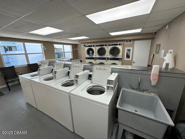 shared laundry area with separate washer and dryer and a sink