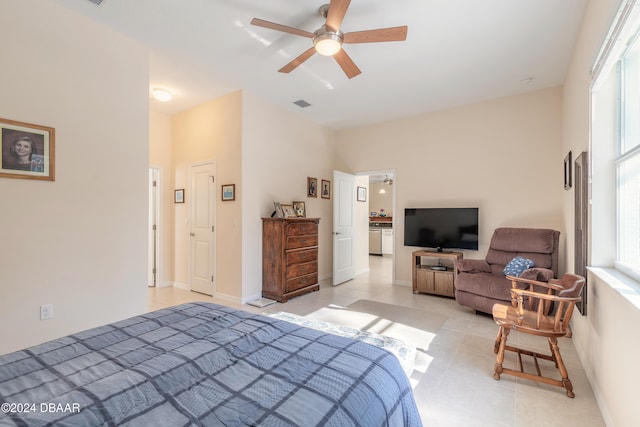 tiled bedroom with ceiling fan and multiple windows