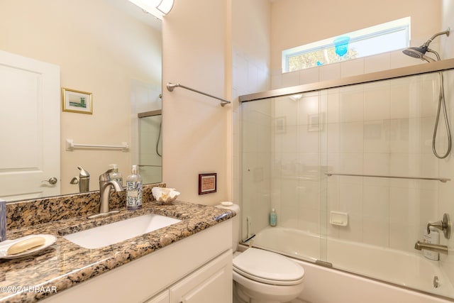 full bathroom with vanity, combined bath / shower with glass door, and toilet