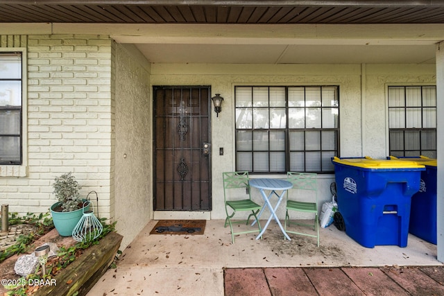 view of exterior entry featuring covered porch