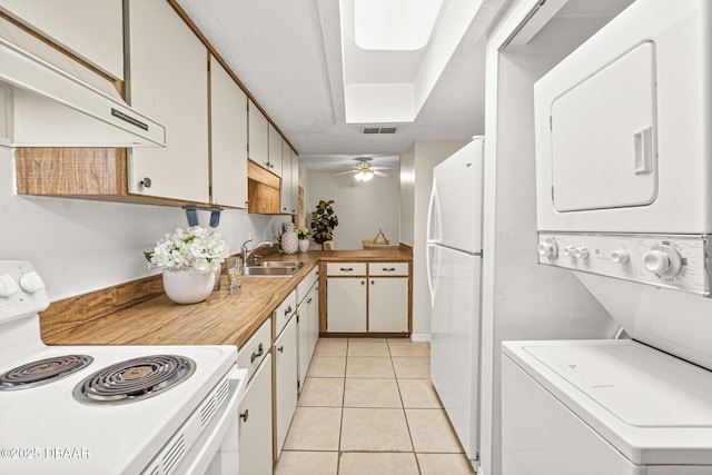 kitchen with white cabinetry, white appliances, and stacked washing maching and dryer