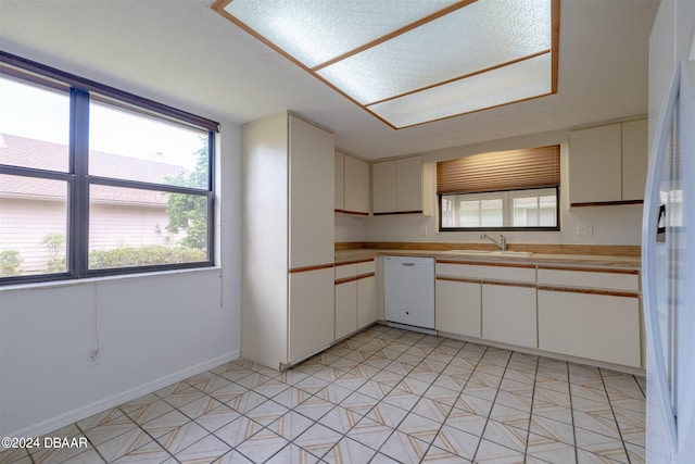 kitchen with white appliances, white cabinetry, and sink