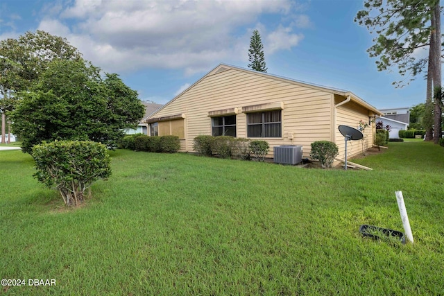 view of property exterior with a yard and cooling unit