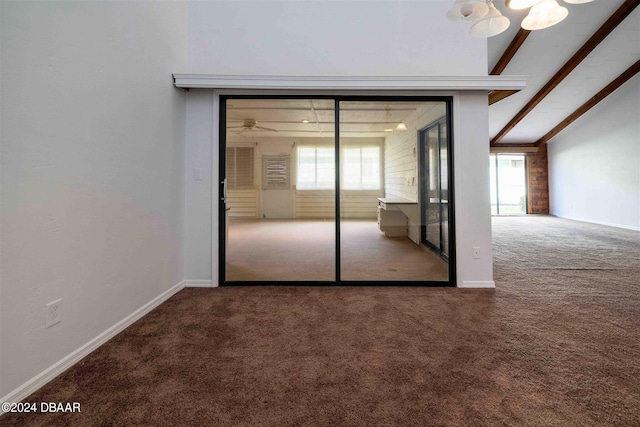 carpeted spare room with vaulted ceiling with beams