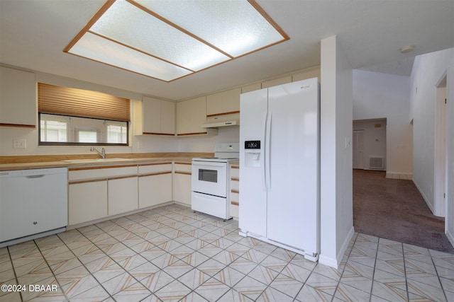 kitchen featuring white appliances, sink, light colored carpet, and vaulted ceiling