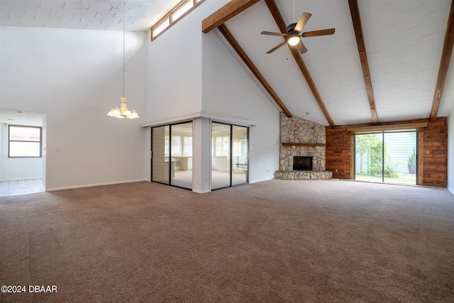 unfurnished living room featuring a fireplace, ceiling fan with notable chandelier, high vaulted ceiling, and carpet floors