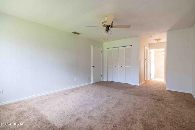 unfurnished bedroom featuring ceiling fan, a closet, and carpet floors