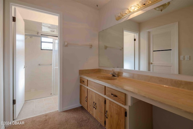 bathroom with vanity, tile patterned floors, and a tile shower