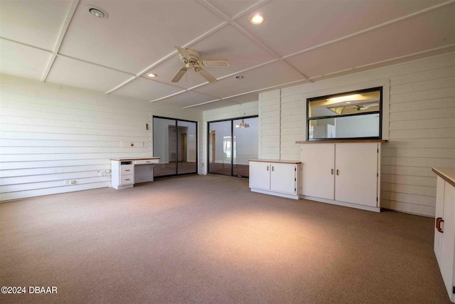 unfurnished living room featuring light carpet and ceiling fan