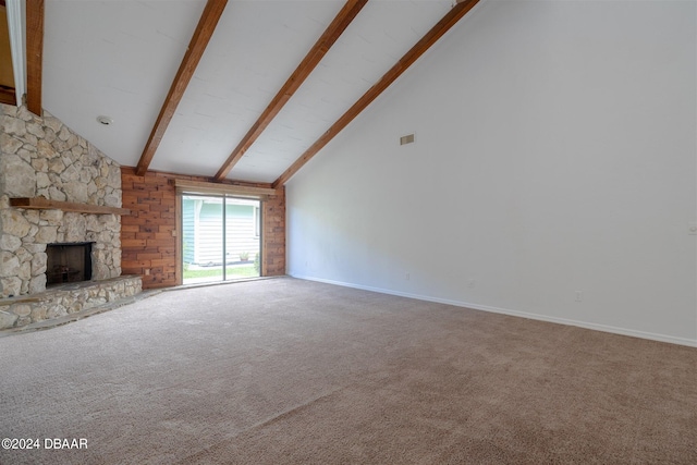 unfurnished living room featuring a stone fireplace, high vaulted ceiling, carpet floors, and beam ceiling