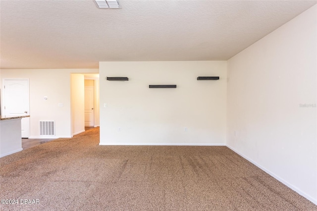 carpeted spare room with a textured ceiling