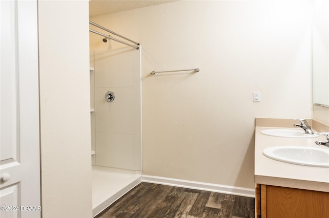 bathroom featuring a shower, wood-type flooring, vanity, and a textured ceiling