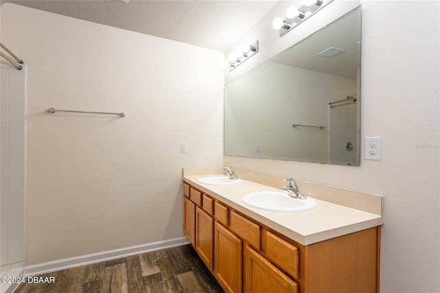 bathroom with hardwood / wood-style flooring, vanity, and a textured ceiling