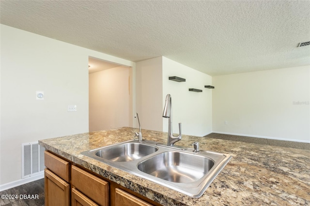 kitchen featuring dark hardwood / wood-style flooring, sink, and a textured ceiling