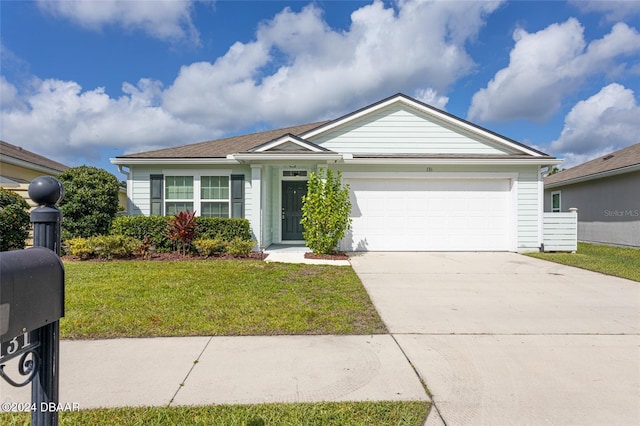 ranch-style house with a garage and a front lawn