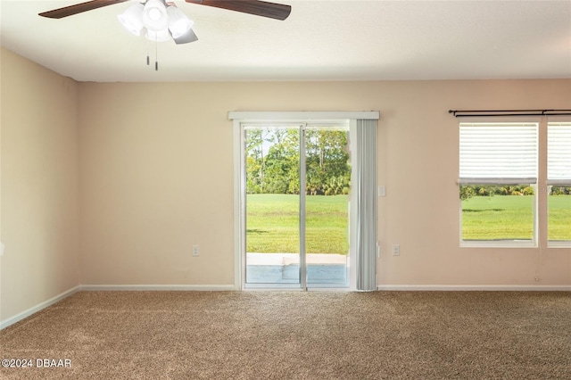 carpeted empty room with ceiling fan and plenty of natural light