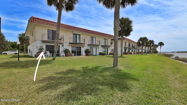 exterior space featuring a front lawn and a balcony