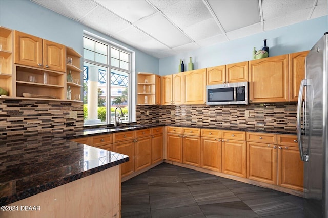 kitchen with dark stone counters, appliances with stainless steel finishes, sink, and plenty of natural light