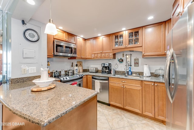 2800 N Atlantic Ave Unit 501, Daytona Beach, FL 32118 - kitchen featuring appliances with stainless steel finishes, a peninsula, glass insert cabinets, light stone counters, and light tile patterned flooring