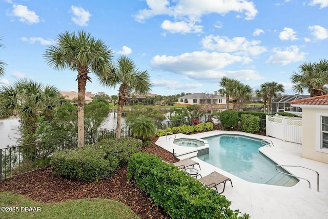 view of swimming pool with an in ground hot tub and a water view