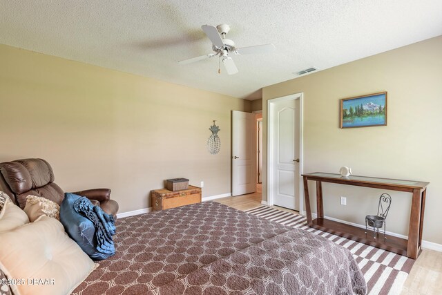 6273 Paradise Island Ct, Port Orange, FL 32128 - bedroom featuring baseboards, wood finished floors, ceiling fan, and a textured ceiling