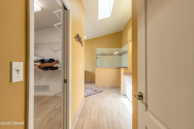 6273 Paradise Island Ct, Port Orange, FL 32128 - hall with vaulted ceiling, a skylight, and tile patterned floors