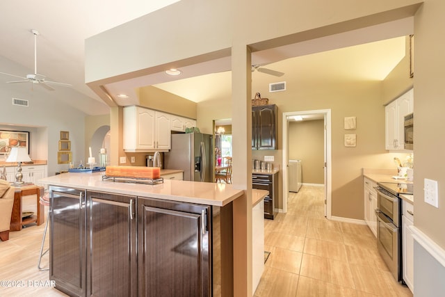 6273 Paradise Island Ct, Port Orange, FL 32128 - kitchen featuring ceiling fan, appliances with stainless steel finishes, arched walkways, vaulted ceiling, and white cabinets
