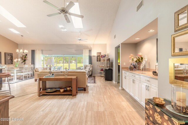 6273 Paradise Island Ct, Port Orange, FL 32128 - living room featuring a skylight, a ceiling fan, a chandelier, and high vaulted ceiling
