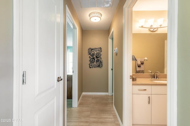 6273 Paradise Island Ct, Port Orange, FL 32128 - hallway with a sink, a textured ceiling, and baseboards