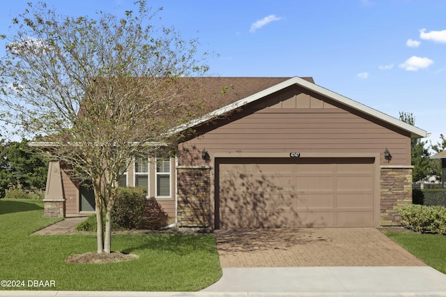 ranch-style home featuring a garage and a front lawn