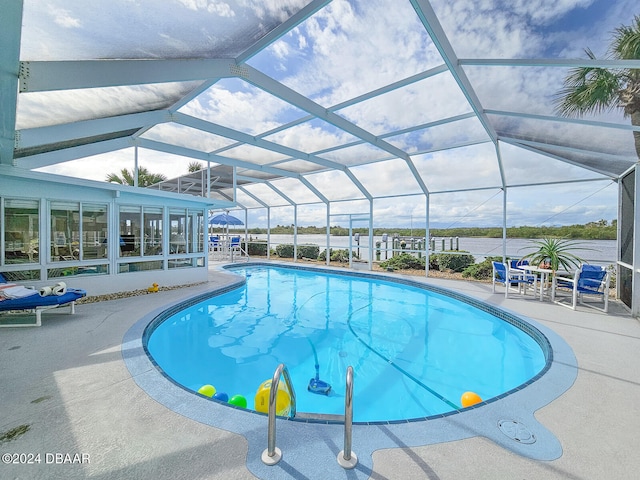 view of pool with glass enclosure and a patio area