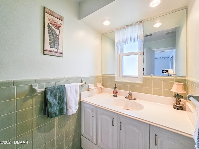 bathroom with vanity and tile walls