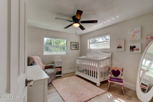 22 Cedar St, Port Orange, FL 32127 - bedroom featuring multiple windows, light wood finished floors, baseboards, and a crib