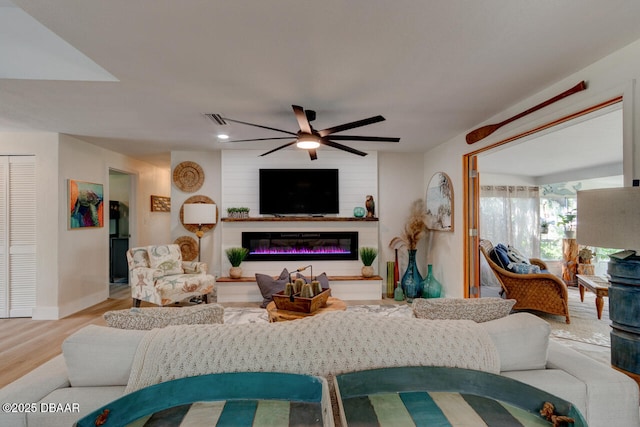 22 Cedar St, Port Orange, FL 32127 - living area with ceiling fan, wood finished floors, a glass covered fireplace, and baseboards