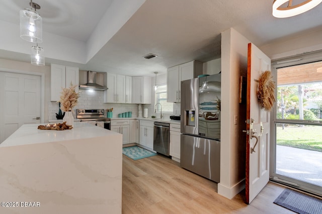 22 Cedar St, Port Orange, FL 32127 - kitchen with stainless steel appliances, wall chimney exhaust hood, decorative backsplash, pendant lighting, and a sink