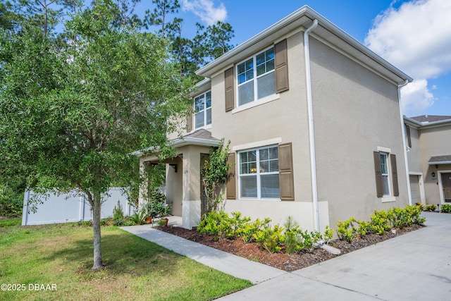 view of front of property with stucco siding and a front lawn