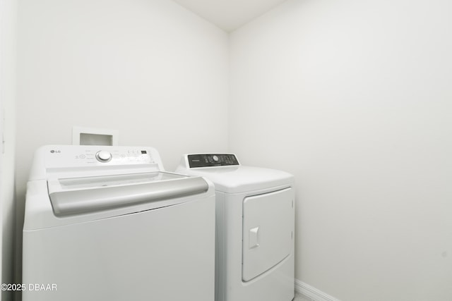 laundry room featuring washer and dryer and baseboards