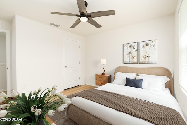 bedroom with wood finished floors, a ceiling fan, and baseboards
