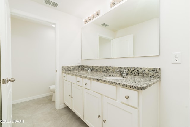 full bath with toilet, double vanity, baseboards, and tile patterned flooring