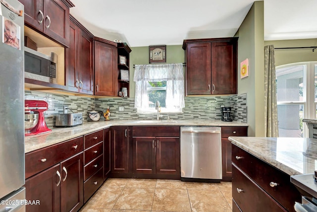 5479 Saint Regis Way, Port Orange, FL 32128 - kitchen featuring stainless steel appliances, reddish brown cabinets, backsplash, and light stone counters