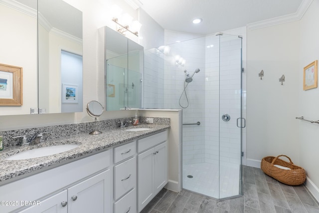 bathroom featuring a shower with door, ornamental molding, and vanity