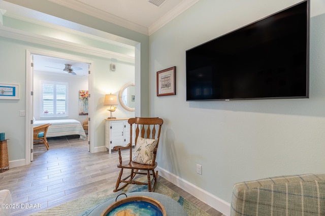 living area featuring crown molding, ceiling fan, and light wood-type flooring