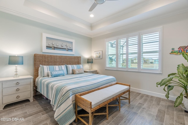 bedroom with crown molding, hardwood / wood-style floors, ceiling fan, and a tray ceiling