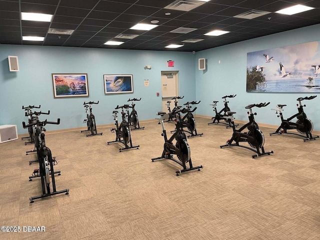 exercise room featuring carpet floors and a paneled ceiling