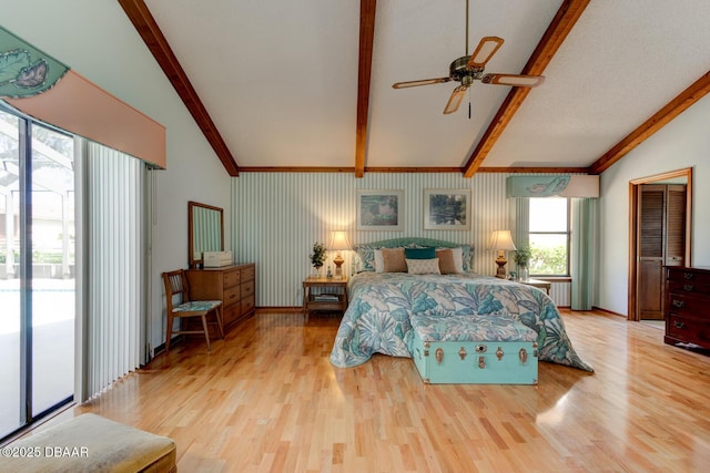 bedroom featuring access to exterior, lofted ceiling with beams, and light wood-style floors