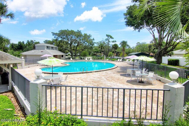 pool with a patio and fence