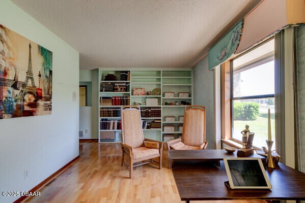 living area featuring wood finished floors and a textured ceiling