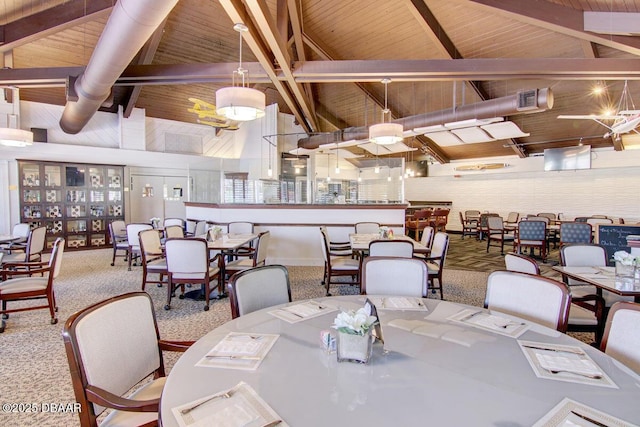 carpeted dining space with beam ceiling, visible vents, and high vaulted ceiling